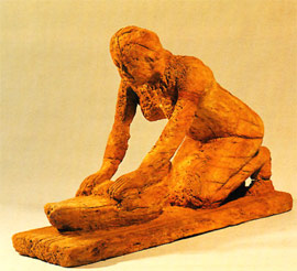 The kneeling woman is depicted while grinding wheat or corn