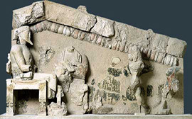 Στο αέτωμα απεικονίζονται από αριστερά, ο Δίας καθισμένος σε θρόνο, η Ήρα, ο Ηρακλής και η Ίριδα.